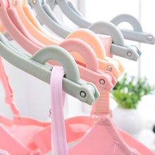 Foldable plastic hanger in vibrant colors, perfect for travel and organizing clothes.